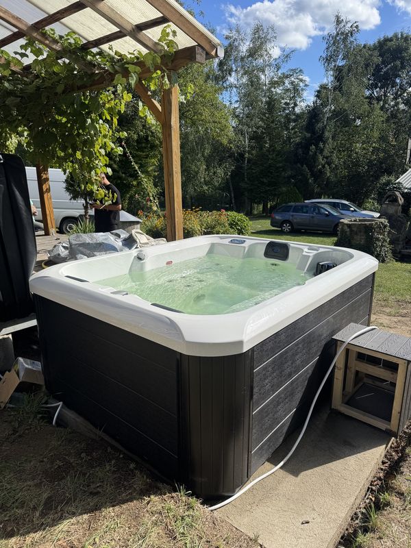 Jacuzzi Pablitto przy drewnianej pergoli porośniętej winoroślą