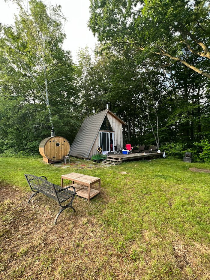 Usługi Rustic cabin and sauna surrounded by lush forest greenery.