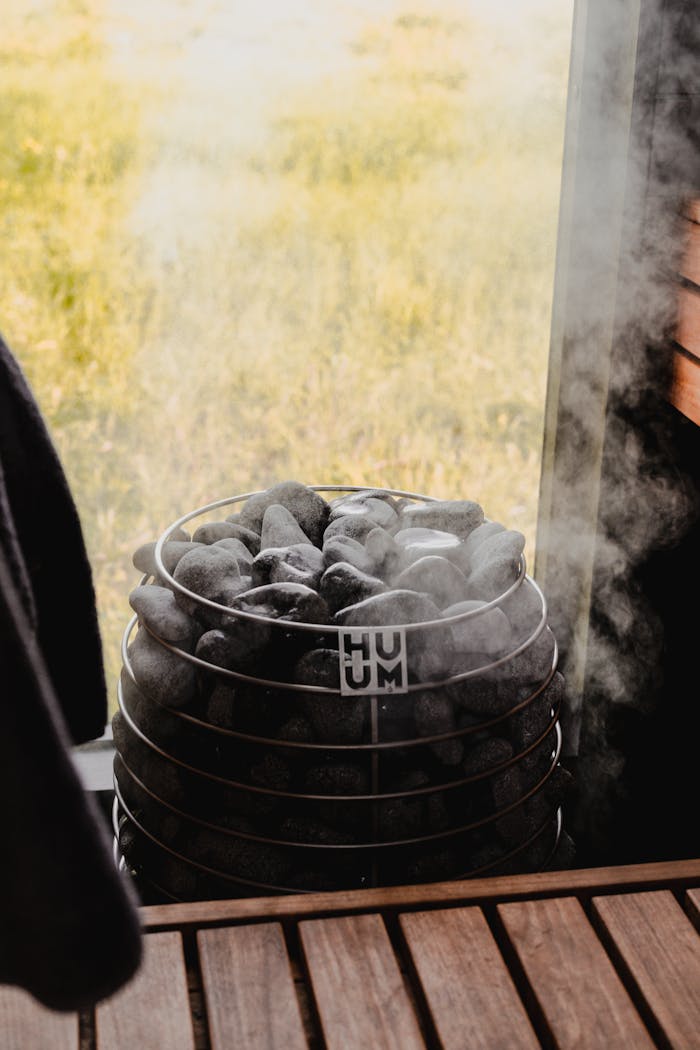Usługi Contemporary sauna featuring a stone heater with steam, emphasizing modern design and relaxation.